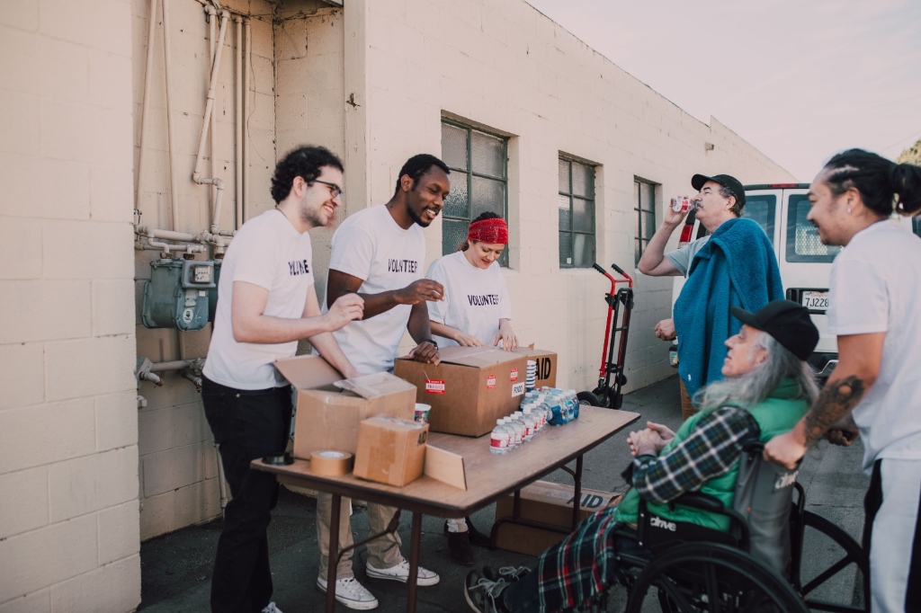 Dedicated community volunteers distributing aid, water, and essential supplies to individuals in need